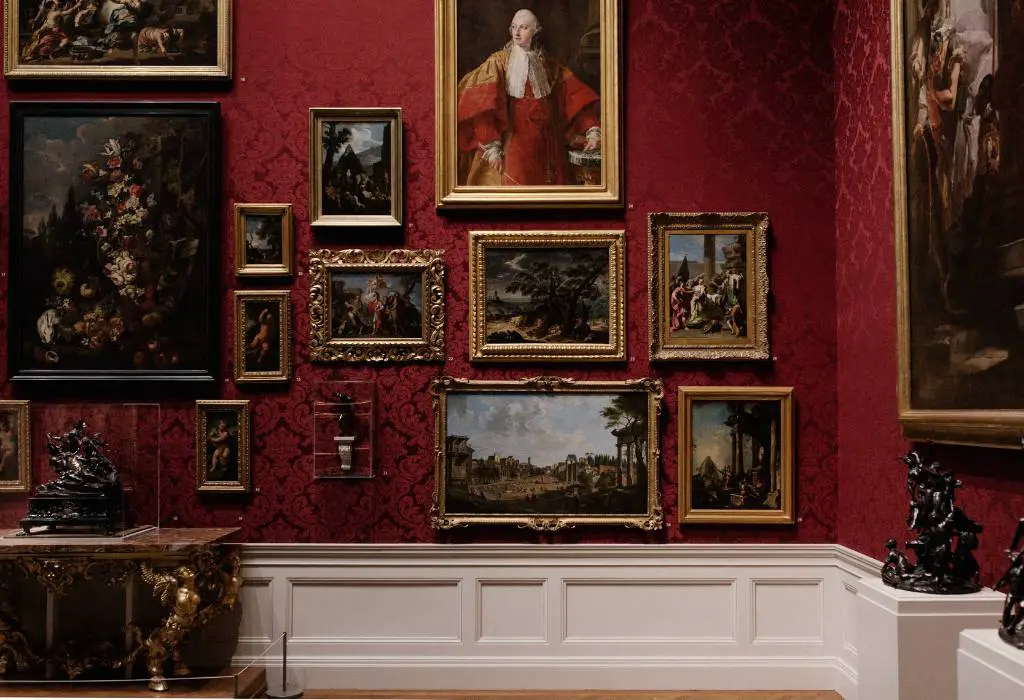 Royal paintings on a red wall. 