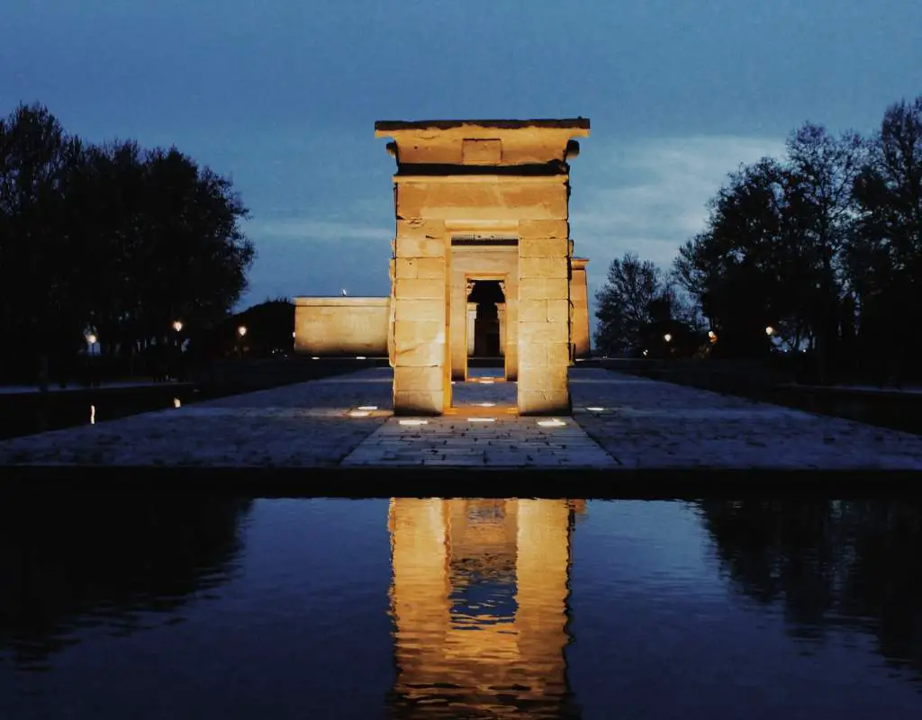 Gray arch with lights in the middle of water in Madrid park